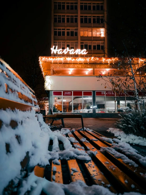 a bench outside a restaurant in the snow