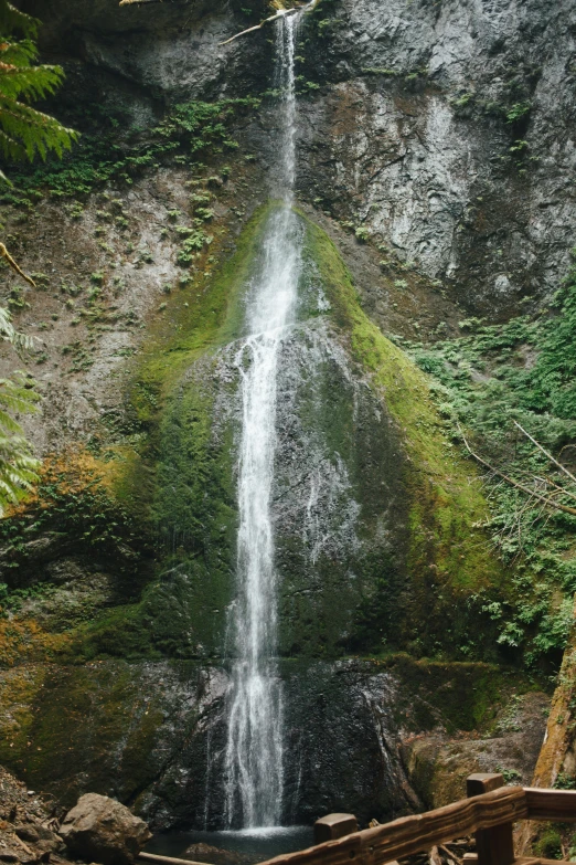 a waterfall cascading over a wooden bridge