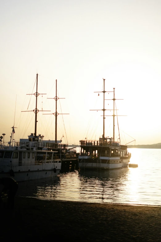 several ships are docked in the water near the shore