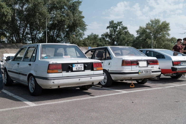 a row of cars with people looking at the back seats