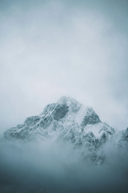 a mountain covered in snow on a cloudy day