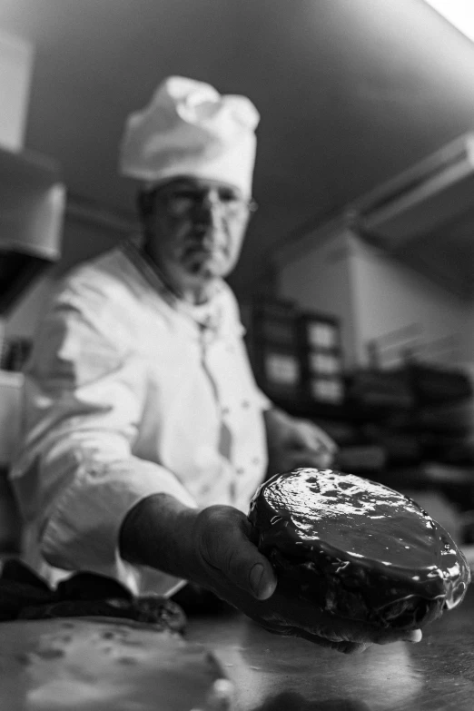 a black and white image of a man preparing food