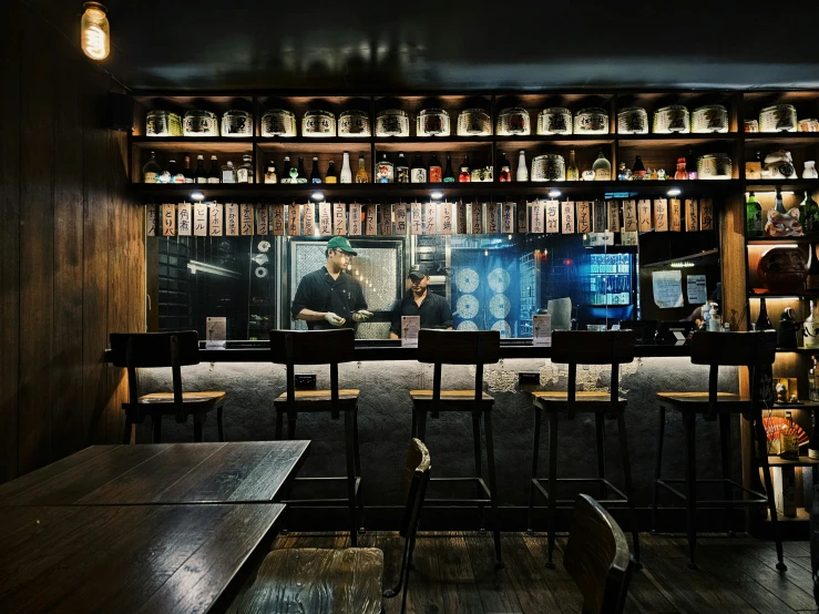 an empty bar with chairs and wooden shelves