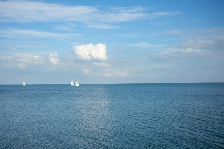 several boats are sailing in the calm ocean