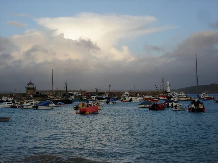 boats float in the water under a stormy sky