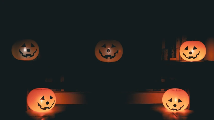 there are three pumpkin heads carved with glowing eyes