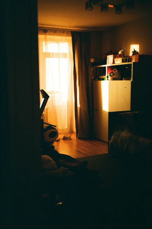 a small living room with a tv and some lights on