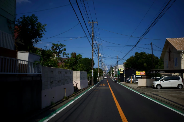 cars are stopped on a quiet street next to power lines