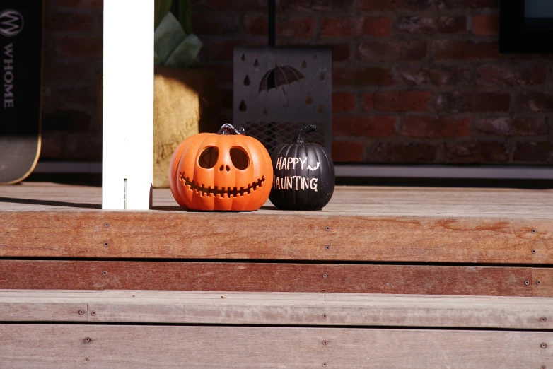 two jack o lantern pumpkins sitting on a porch steps