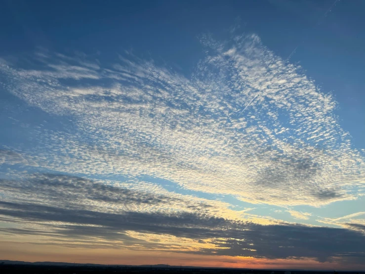 the sky is partly cloudy as the sun rises over some land