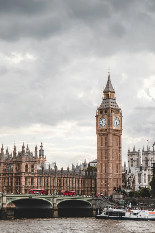 big ben with westminster bridge and a ferry passing under it