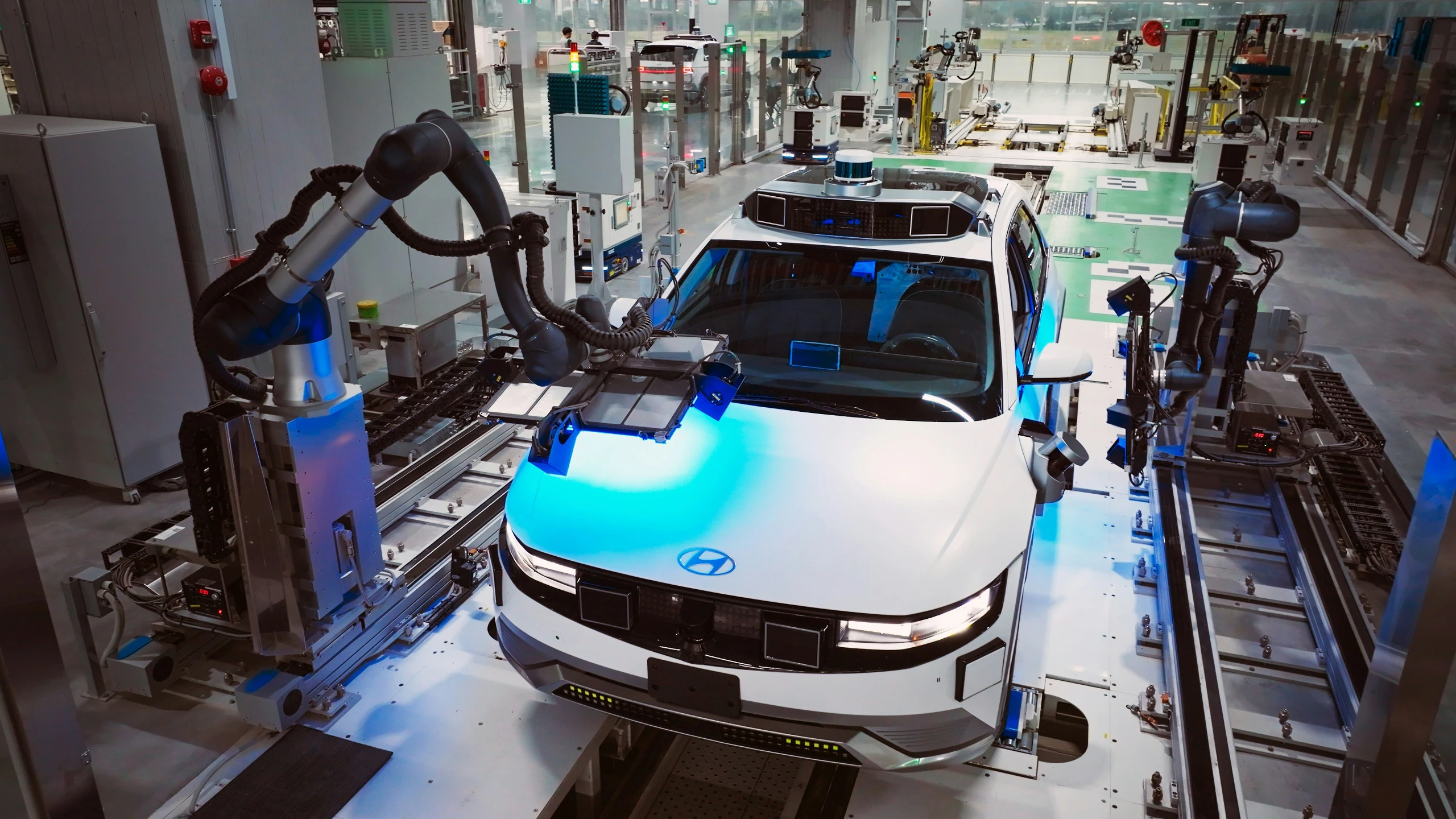 an assembly line at an automobile factory with car being tested for the paint