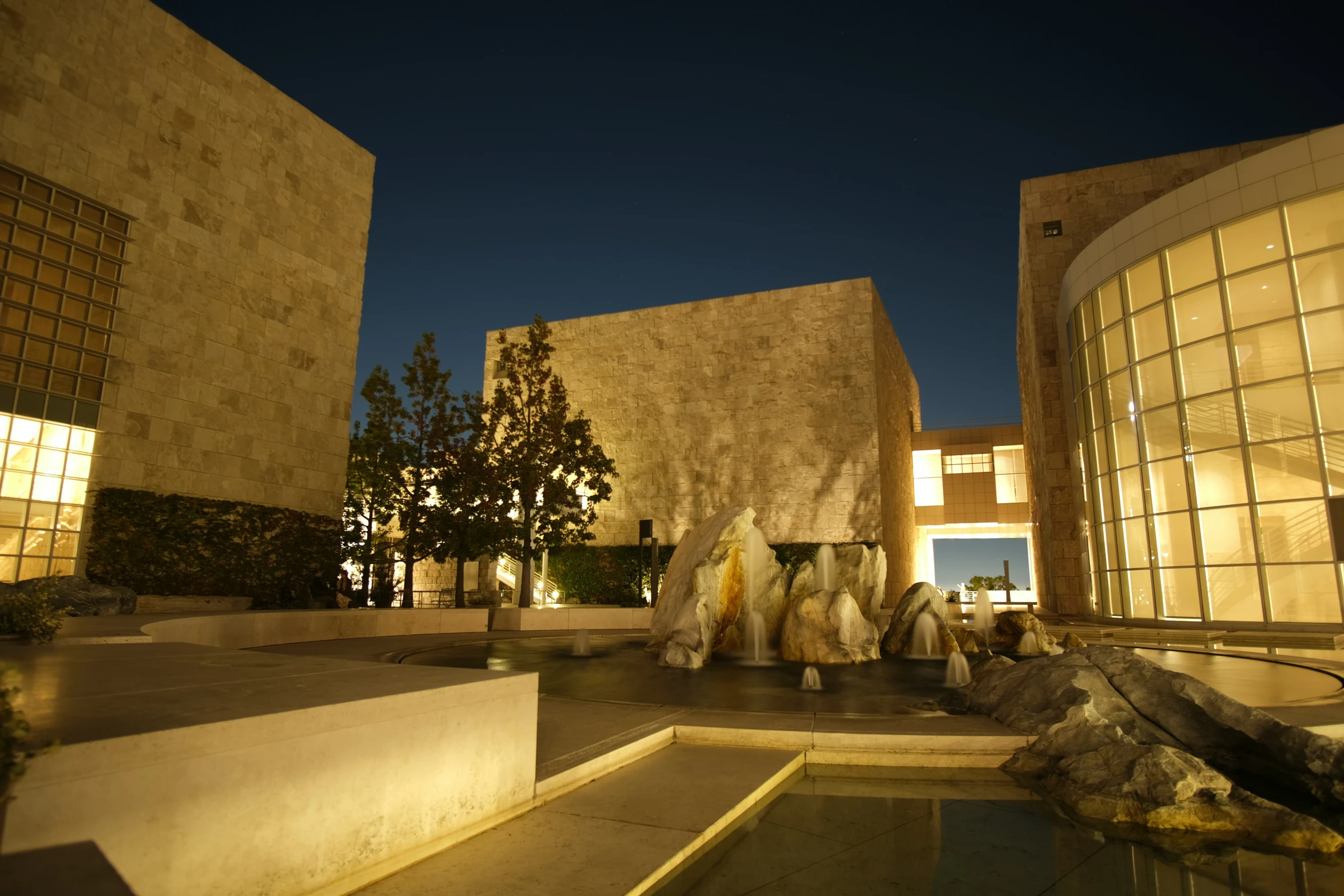 an outdoor building with statues in the courtyard at night