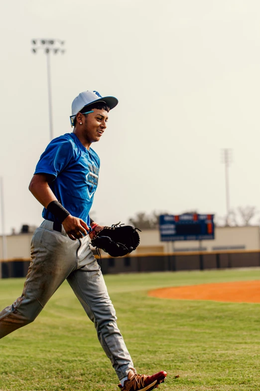 man on baseball field in blue shirt and catchers mitt