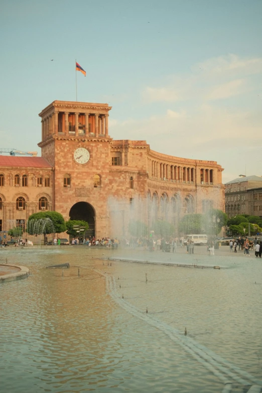 a fountain in front of a building and a clock tower