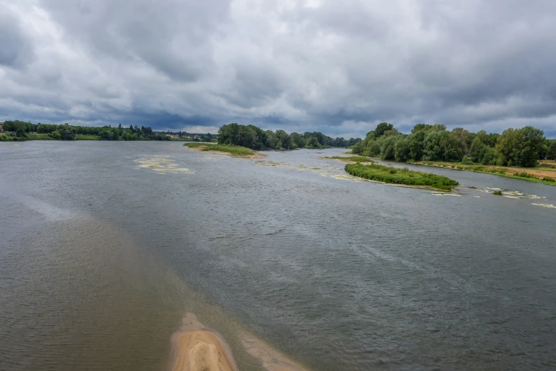 a river with clouds hanging over the trees