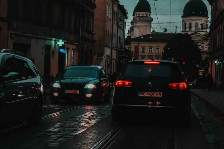 cars driving down an alley at night in the rain