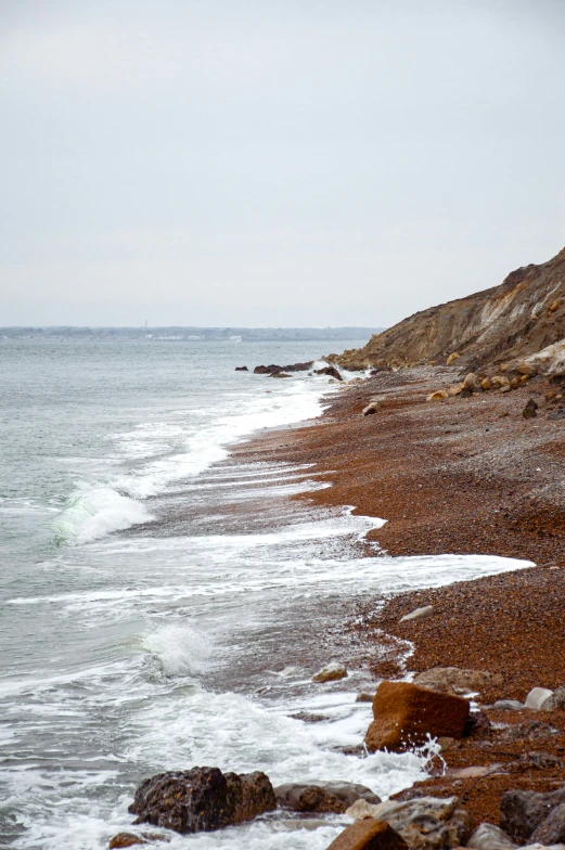 a rocky shore with waves breaking in to the shoreline