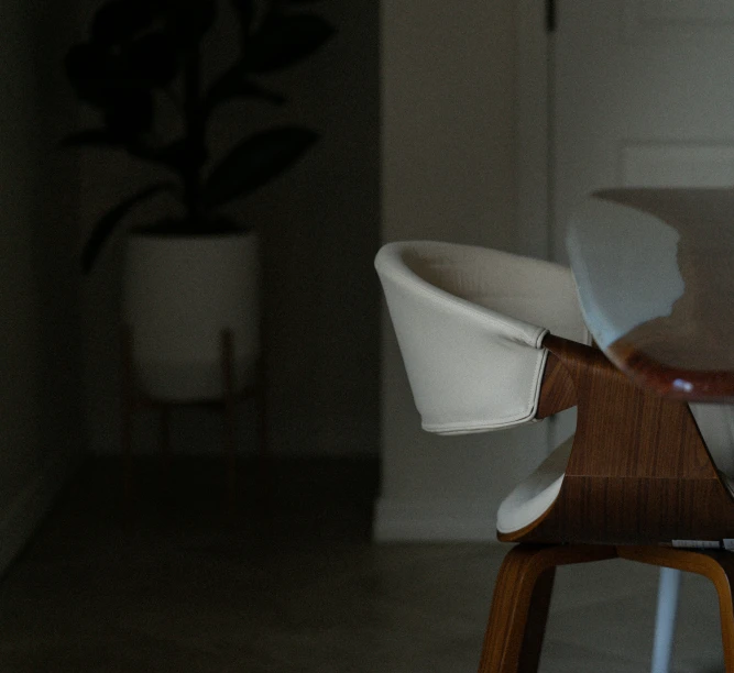 a chair in the dark with a wooden seat