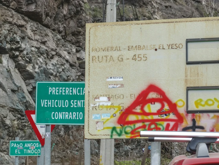 two road signs on the side of a mountain