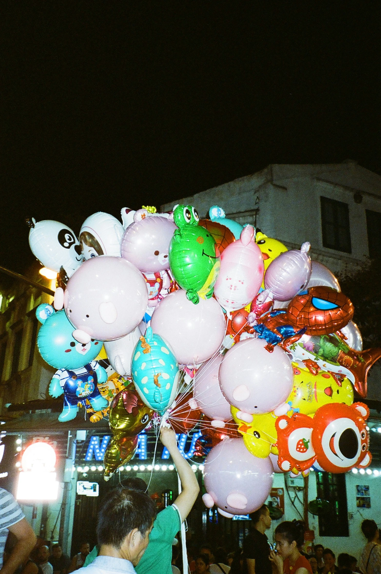 a bunch of balloons and toy animals are shown in the dark