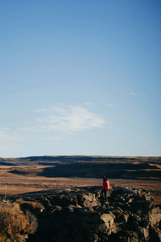 a man stands on the edge of a cliff overlooking a desert