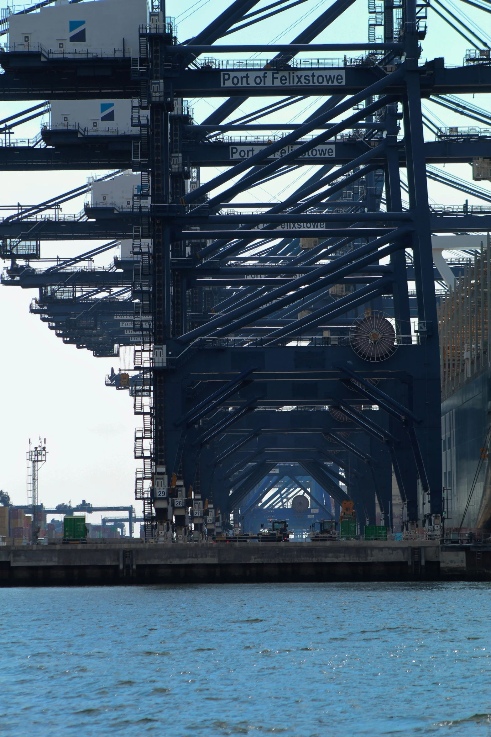 a cargo ship under an enclosed bridge in a harbor