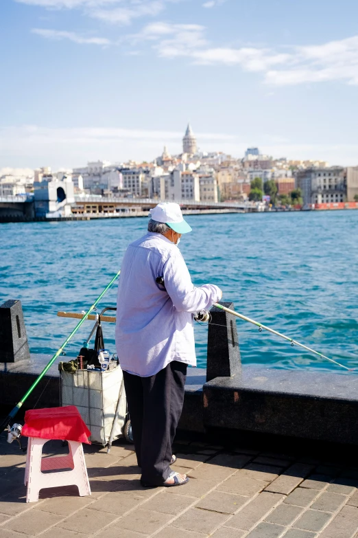 a woman standing on a pier holding a fishing pole