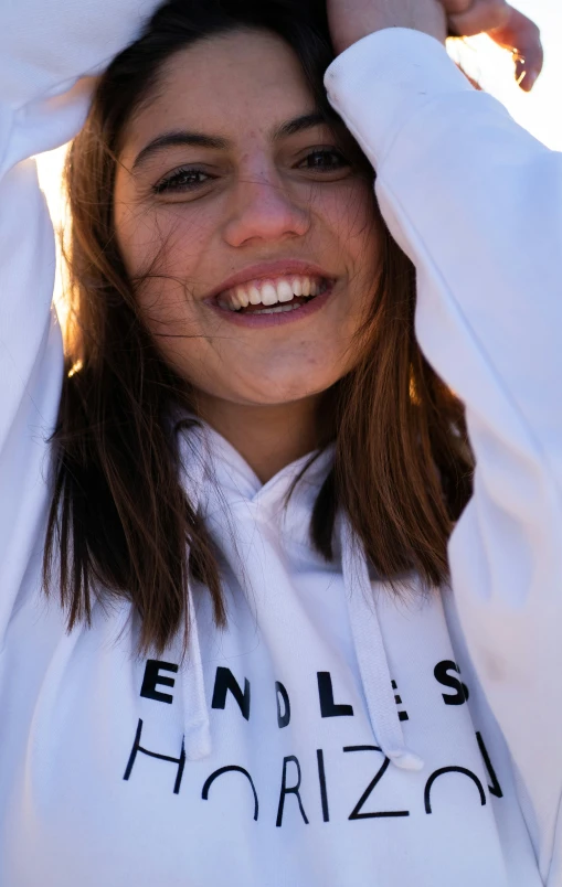 an attractive young woman wearing a white sweatshirt