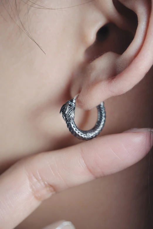 a close - up image of someone holding their ear with the thumb on it