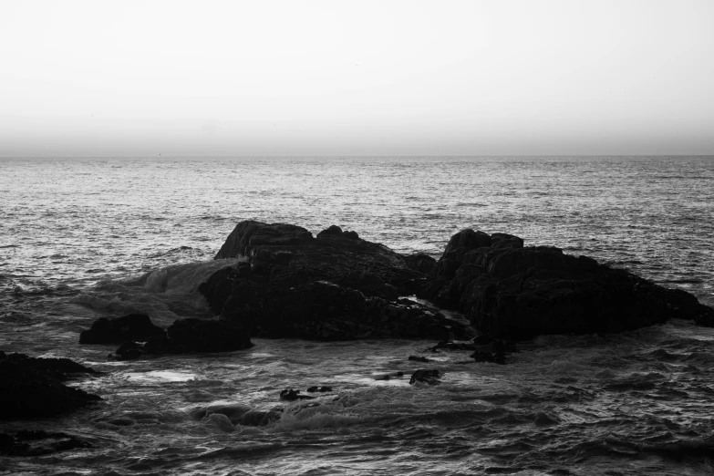 there are three rocks on the coast in the water