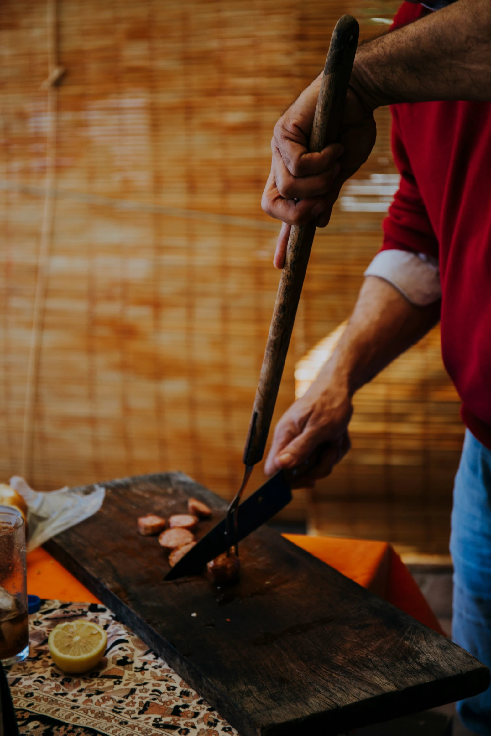 someone using a long knife to cut up food