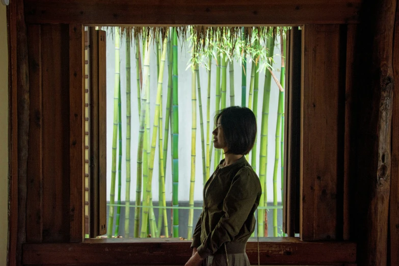 a woman stands in front of the window