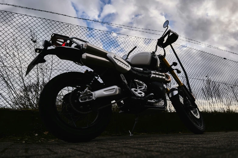 an image of a motorcycle that is parked by the fence