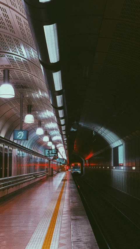 a train station platform with lights and a large white building