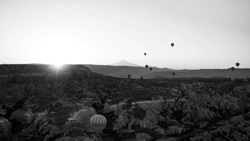 many  air balloons are being flown over the desert