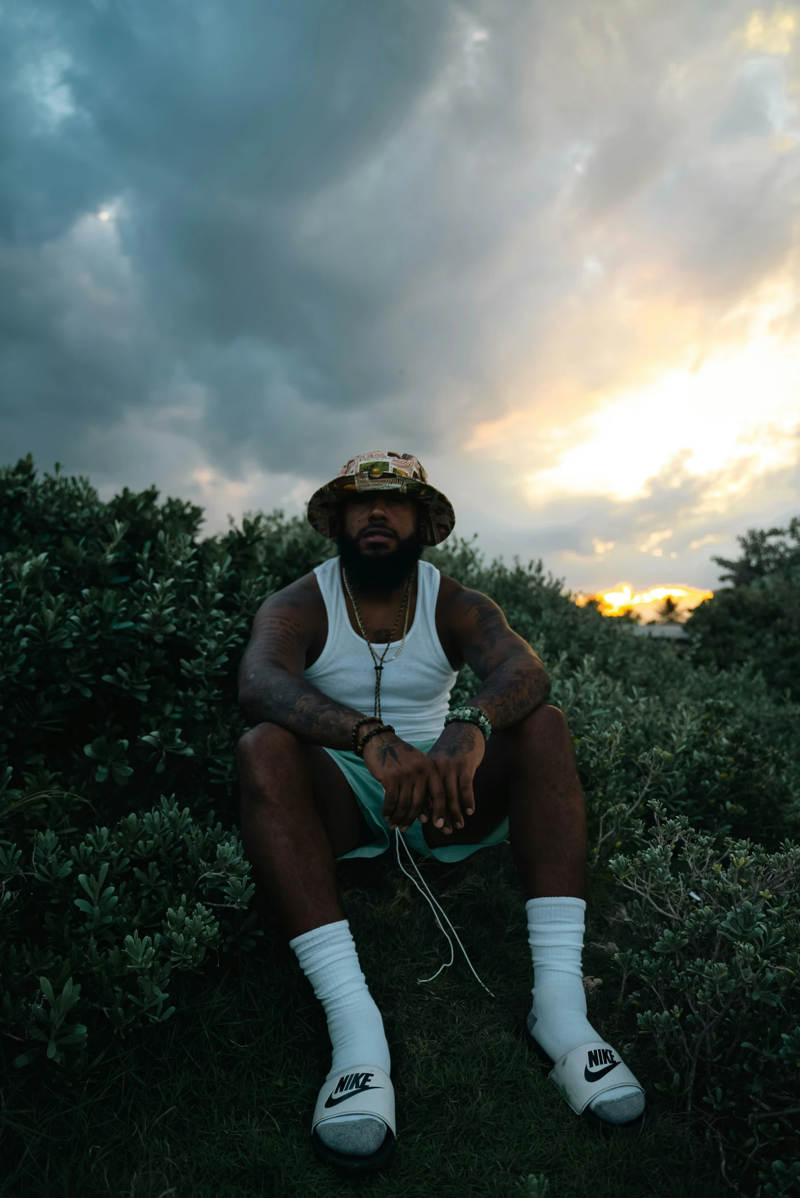 a man sitting on the ground with his legs crossed and head bowed