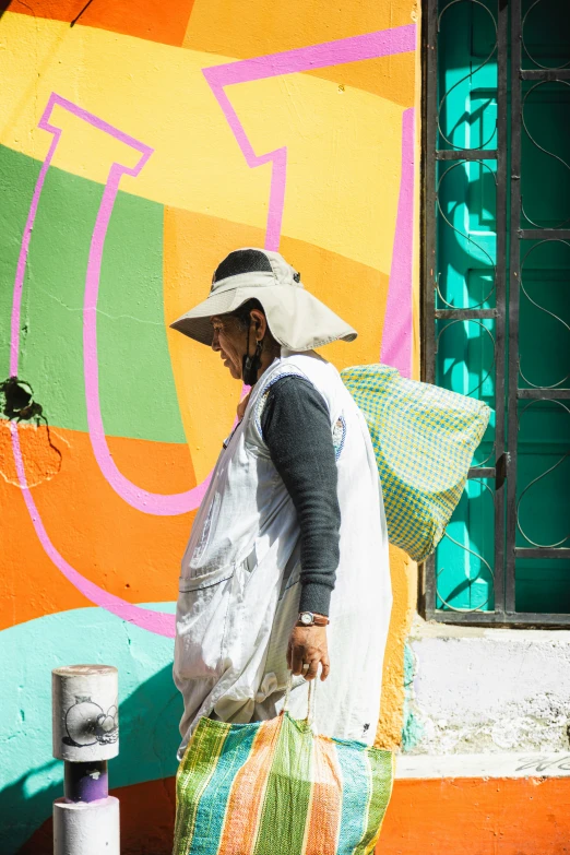 a woman in a hat walking down the street