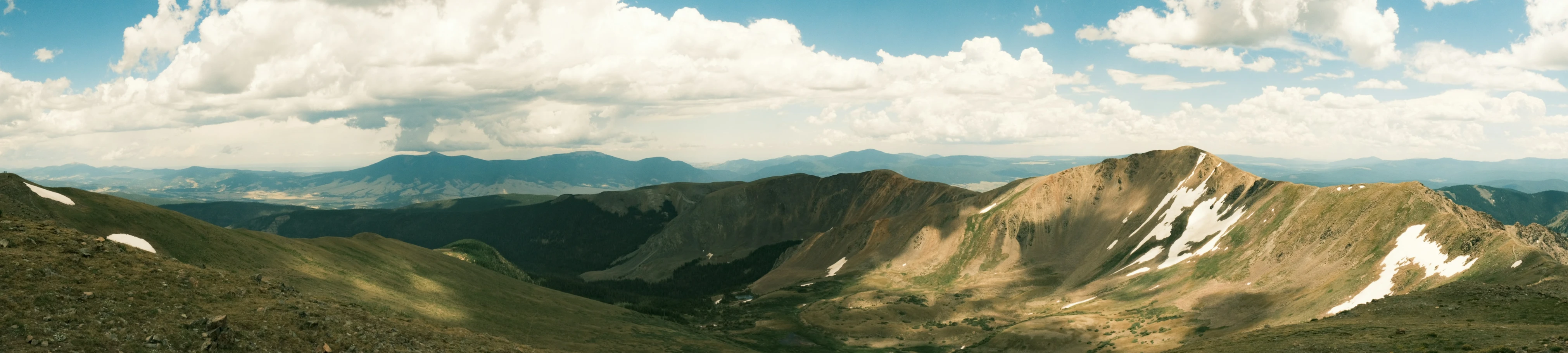 view of hills, clouds and a mountain range