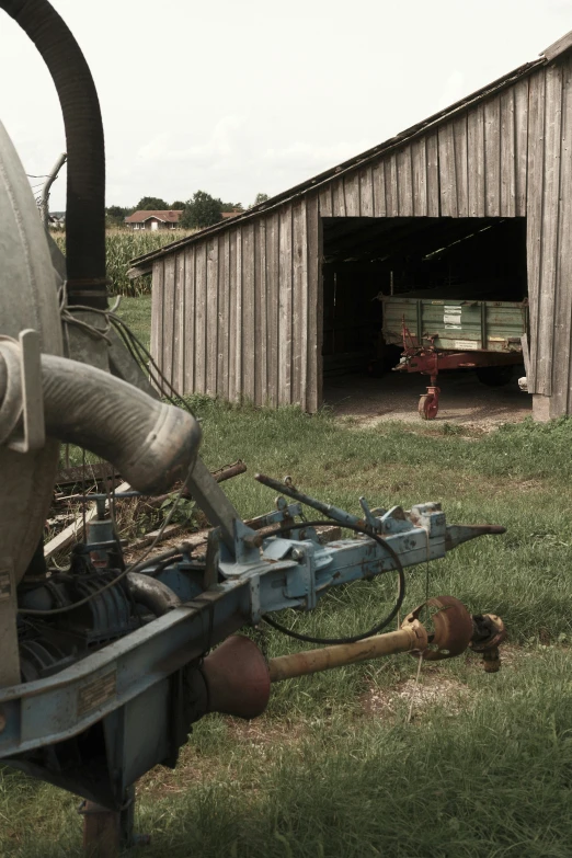 a small old tractor next to a barn