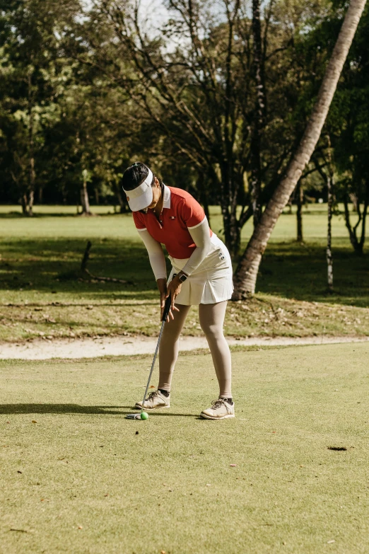 a person on the grass with a golf club in their hands