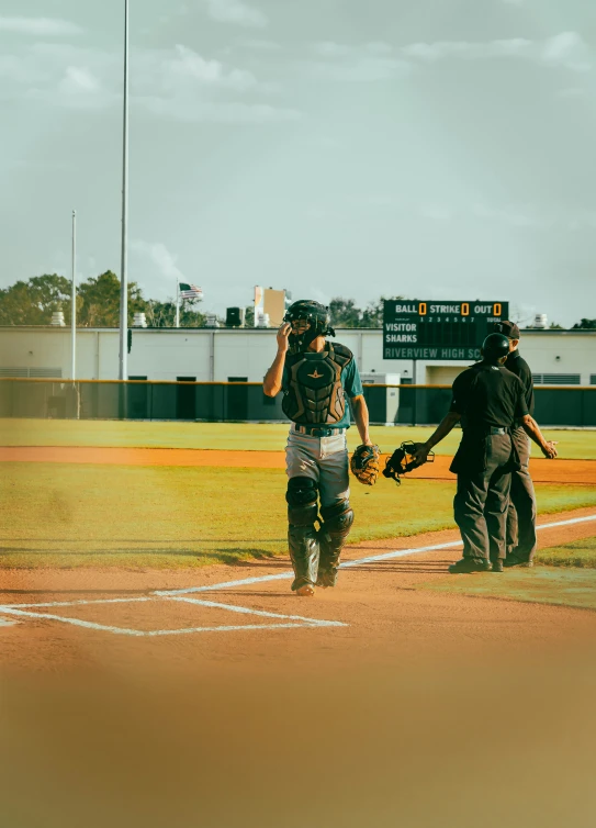 three baseball players walking across the field