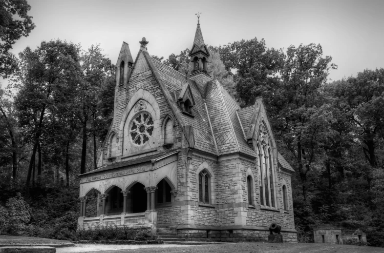 an old gothic style church surrounded by tall trees