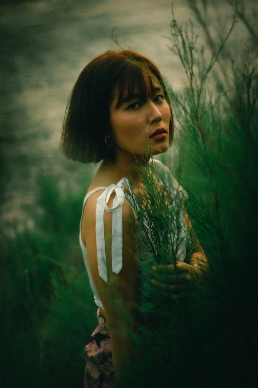 a young woman is standing in a field