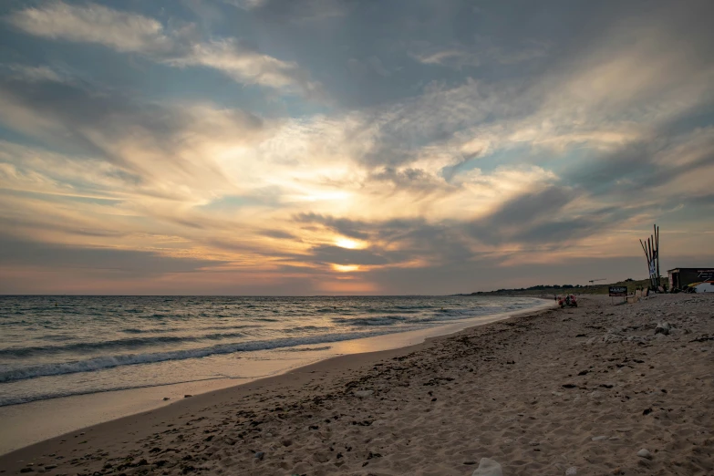 the sun setting at the beach near water