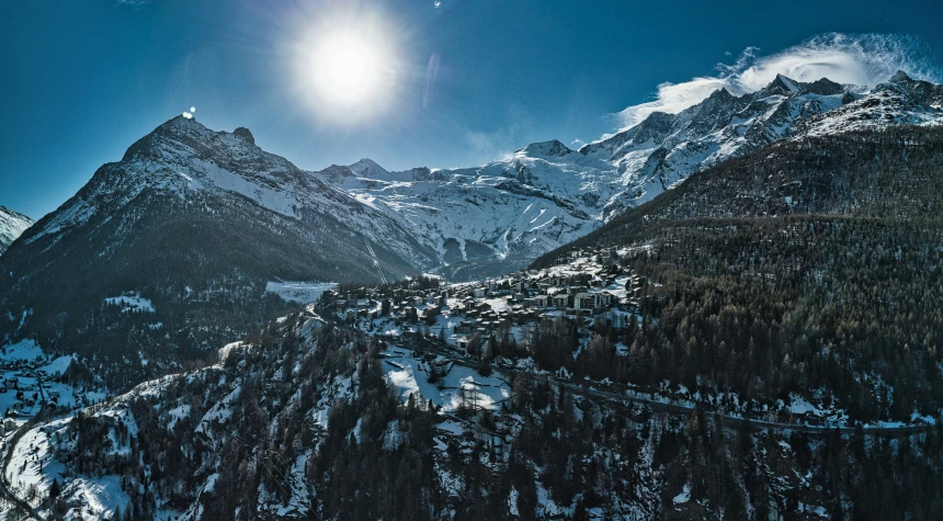 the sun shines brightly over the snow capped mountain peaks