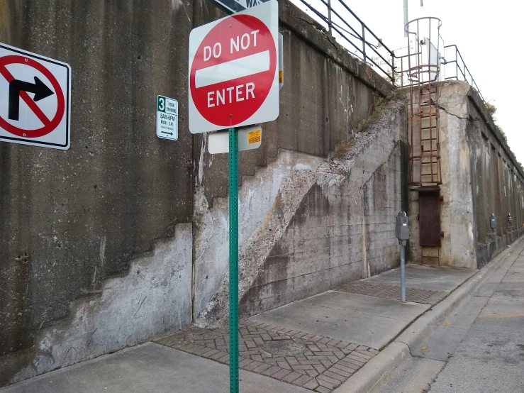a street corner with some signs and a don't enter sign