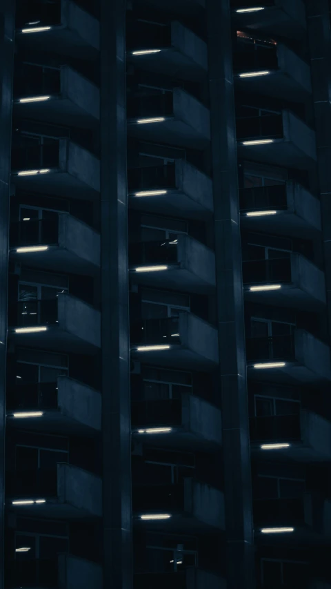 a tall black building with several windows at night