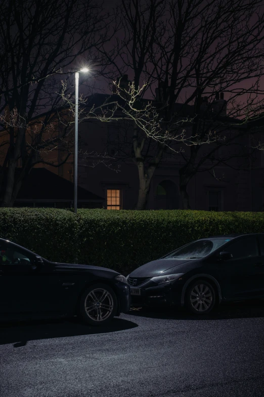 two cars parked at night under the street light