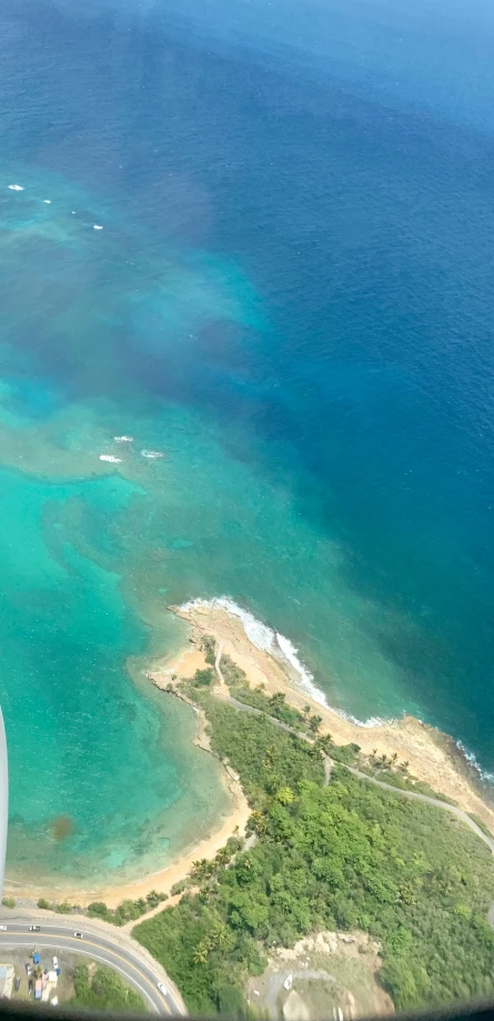 view from inside of an airplane window of land near water